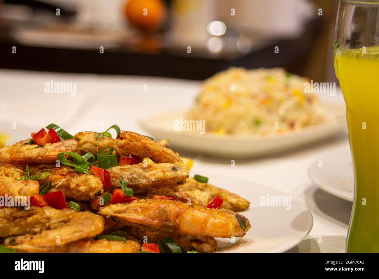 Plate of fried shrimp in tempura with chopped vegetables on table in