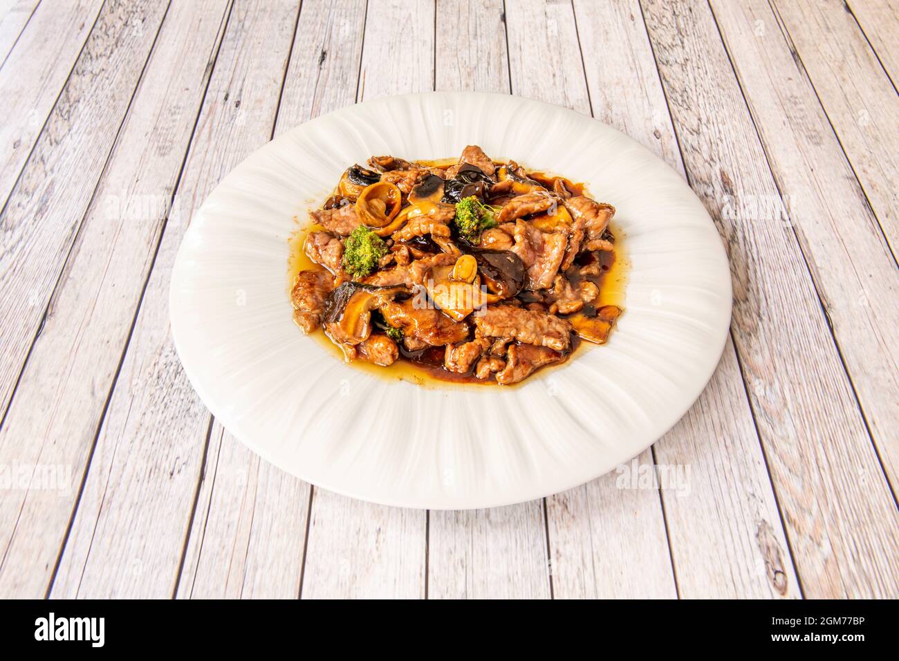 Veal recipe with vegetables and mushrooms with sauce from other Chinese recipe on white plate Stock Photo