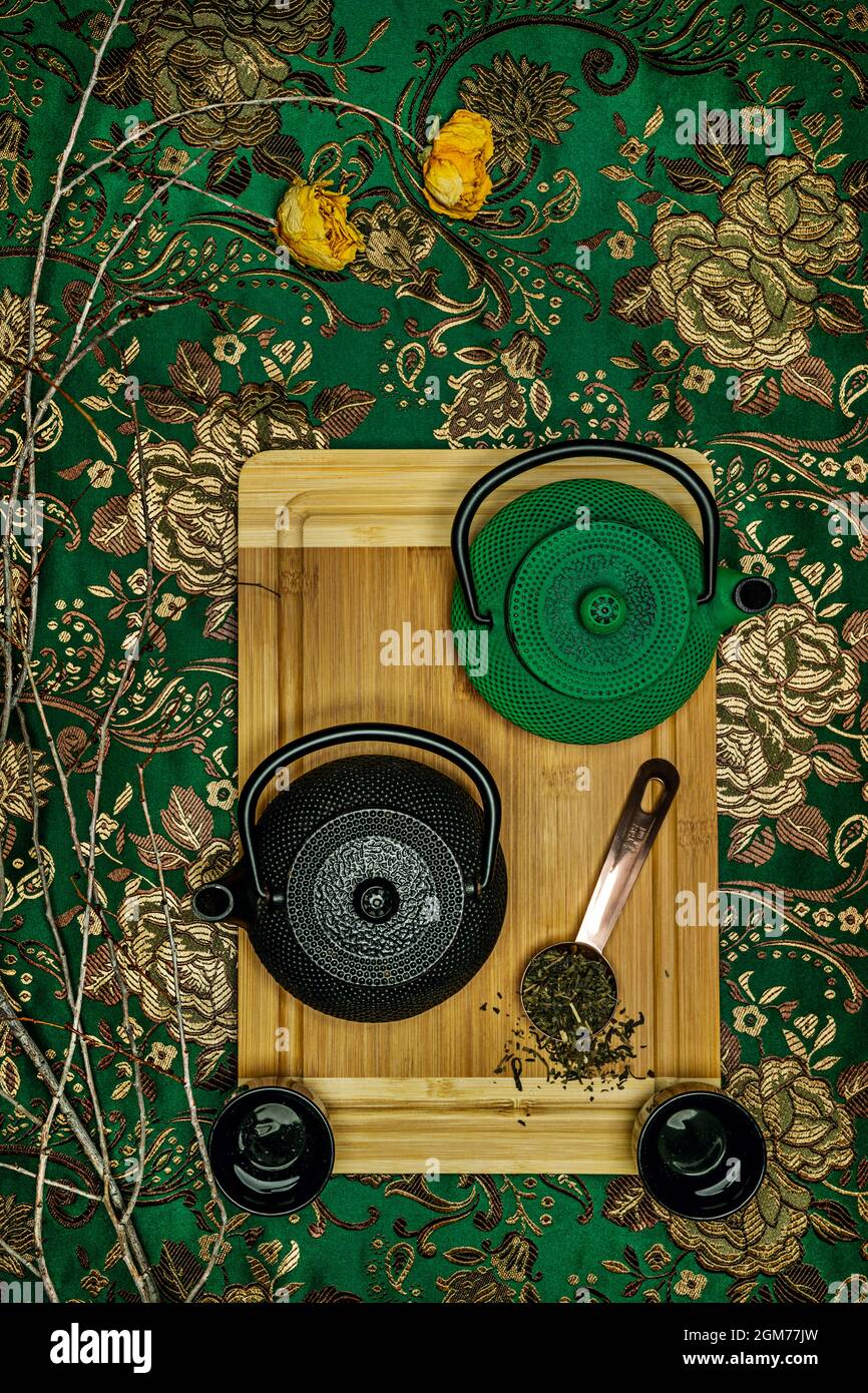 Overhead view of black and green traditional Asian teapots with tea ...