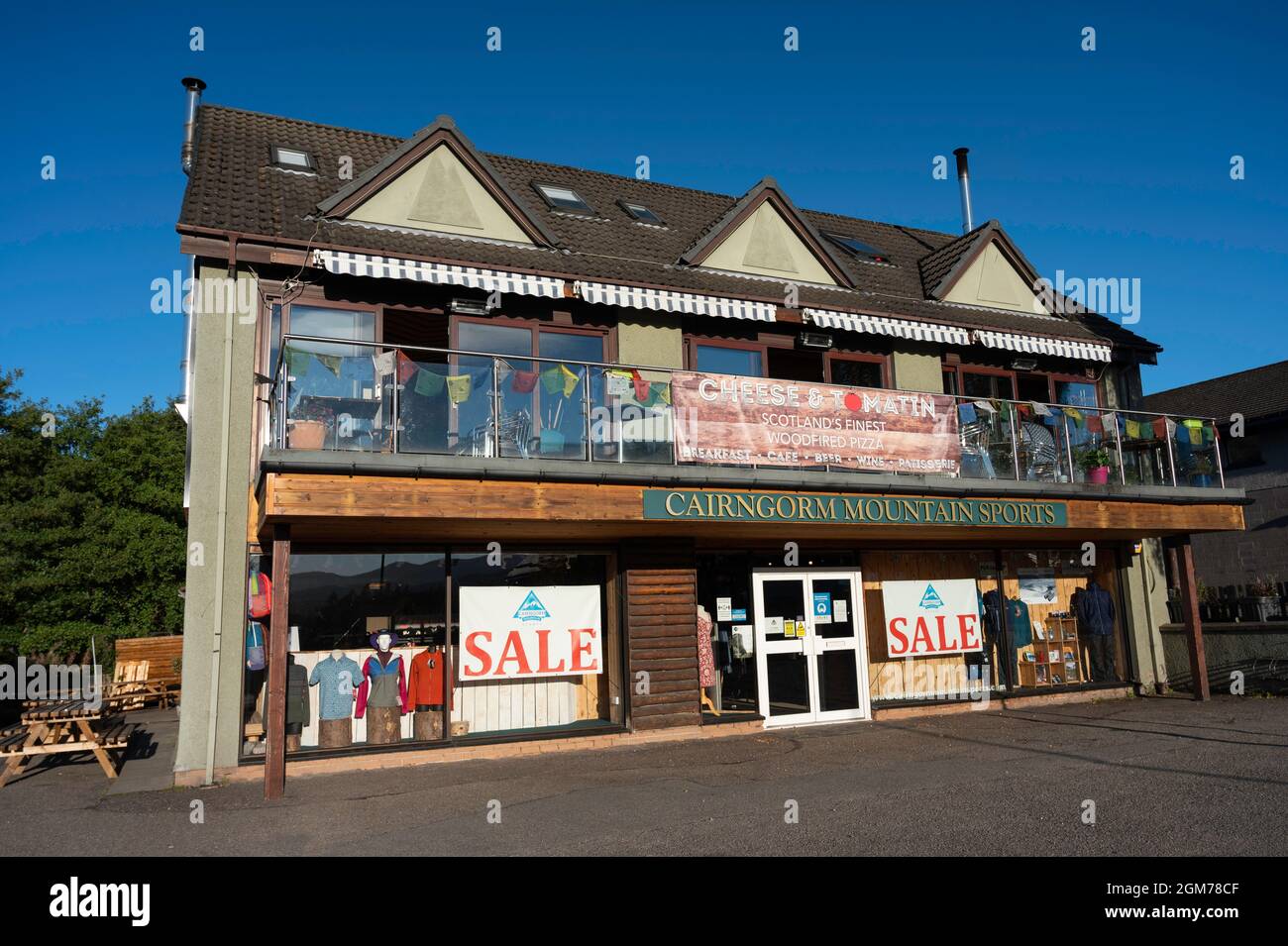 Exterior of Cairngorm Mountain Sports shop with Cheese and Tomatin pizza cafe above. Sunny day, no people, blue sky. Stock Photo