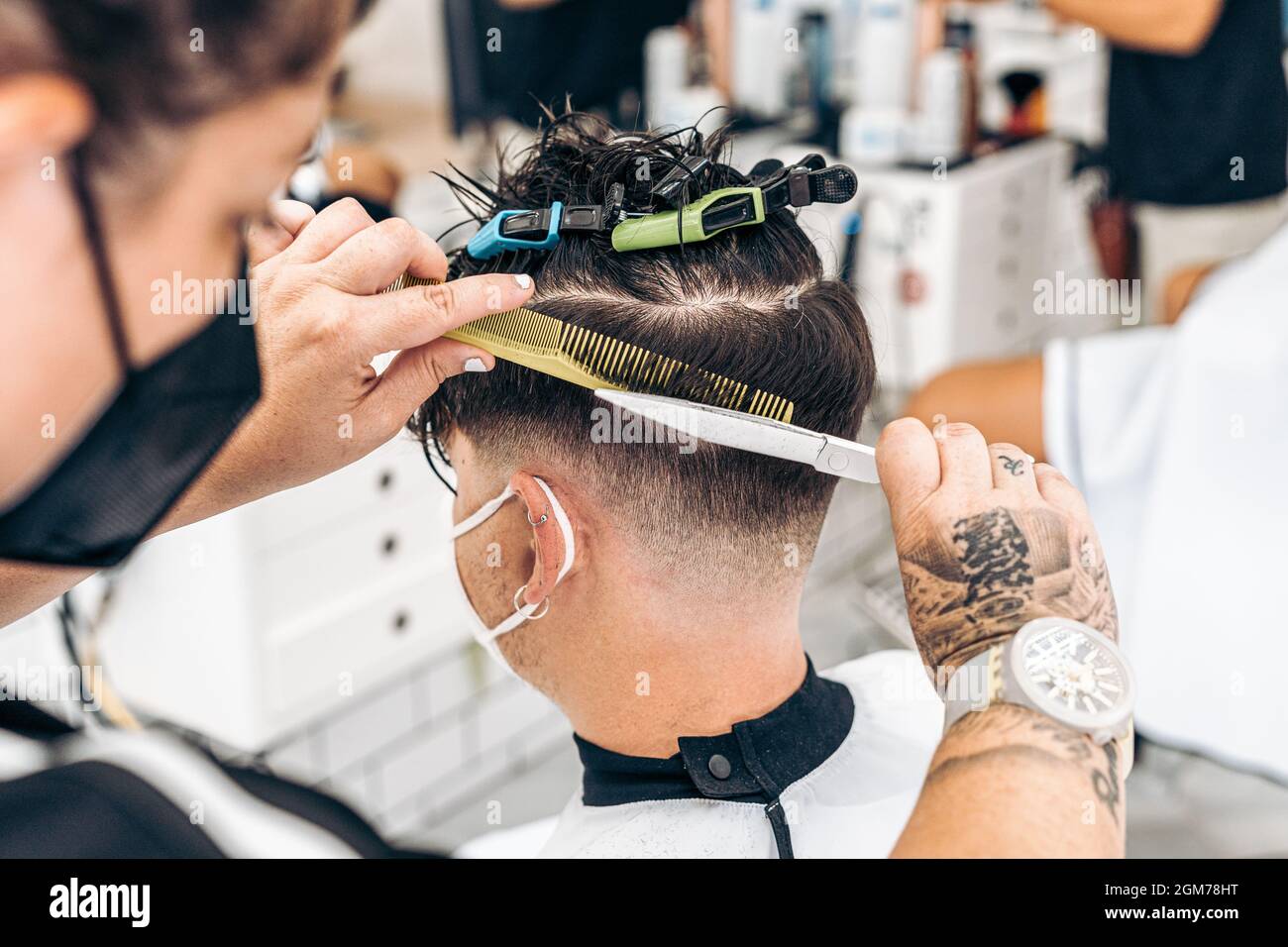 Close up view photo of a hairdresser cutting the hair of a young man Stock Photo