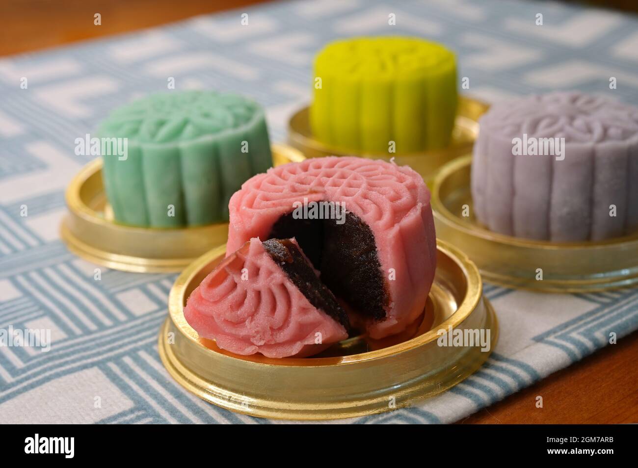 A pink mini snow skin mooncake with red bean filling with floral ...