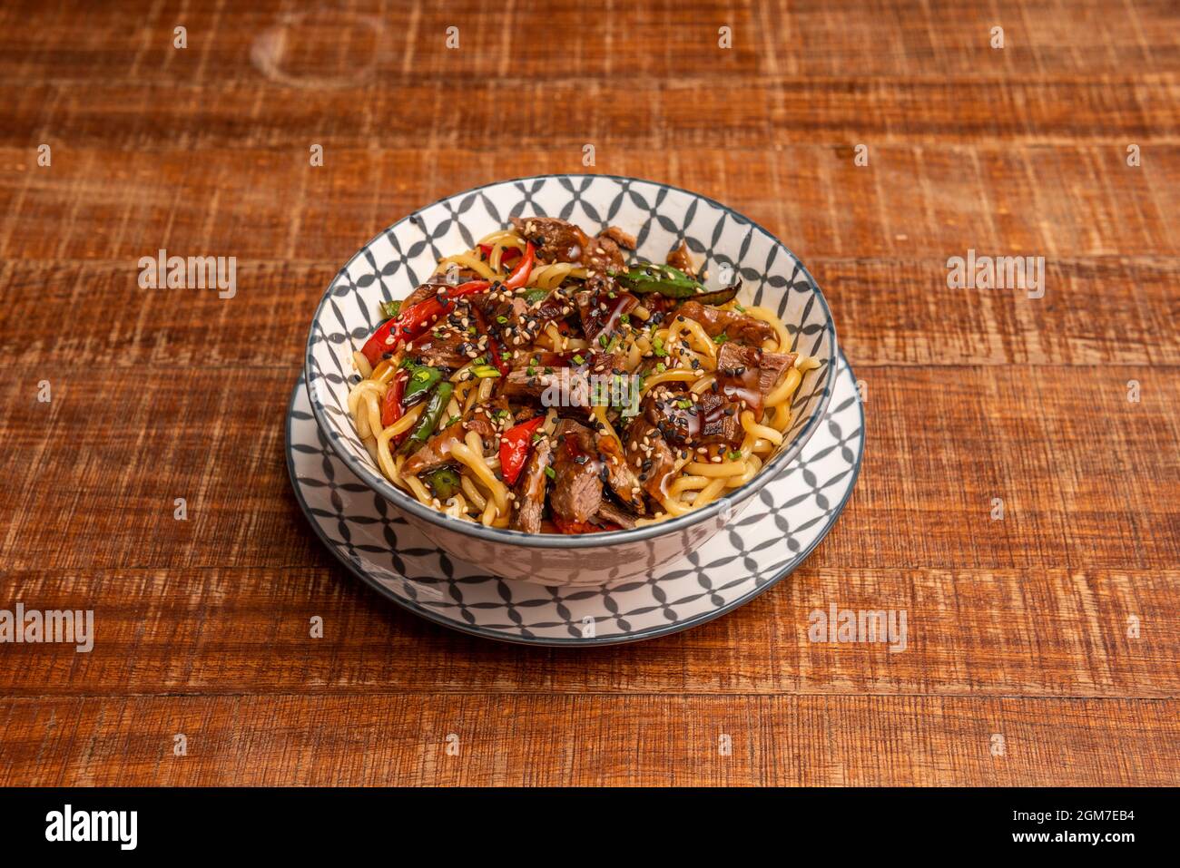 Delicious noodles sautéed with Asian meat, vegetables and seeds