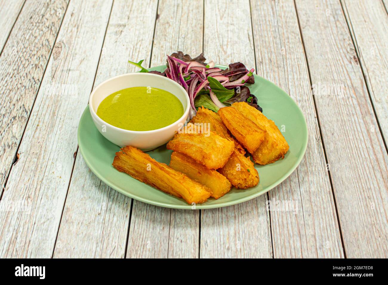 Great fried yucca chunks with guacamole sauce to dip with red onion and lettuce Stock Photo