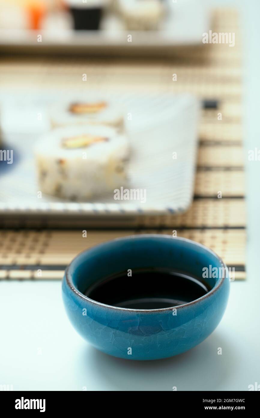 Blue stone bowl filled with soy sauce on a Japanese sushi restaurant table Stock Photo