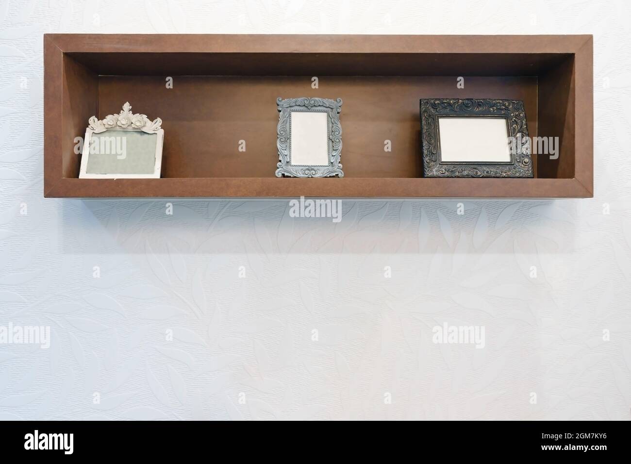 Empty photo frame on wooden shelf with white wall background Stock ...