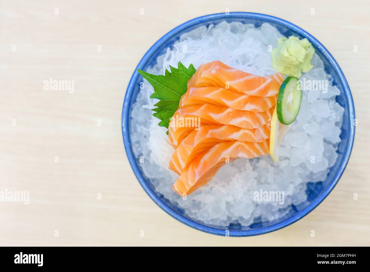 Salmon sashimi on ice serve with fresh wasabi and carrot slide ...