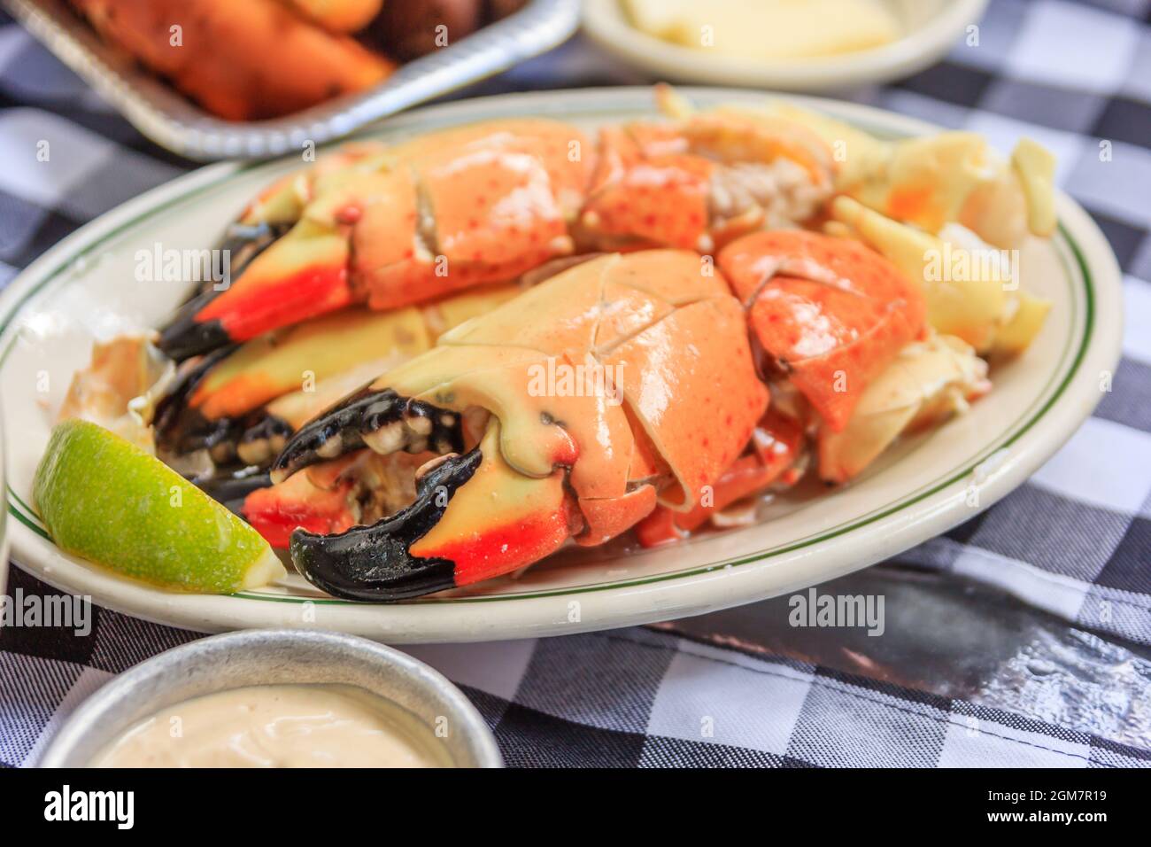 Stone crab claws with lemon butter and mustard on a plate as
