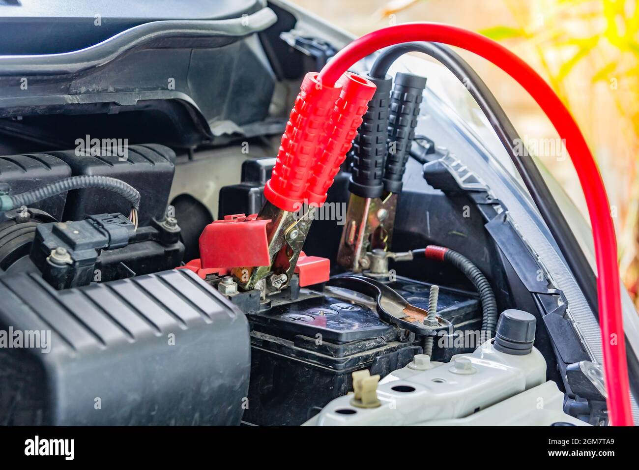 Charging car battery with electricity trough jumper cables,red and black  Jumper cables Stock Photo - Alamy