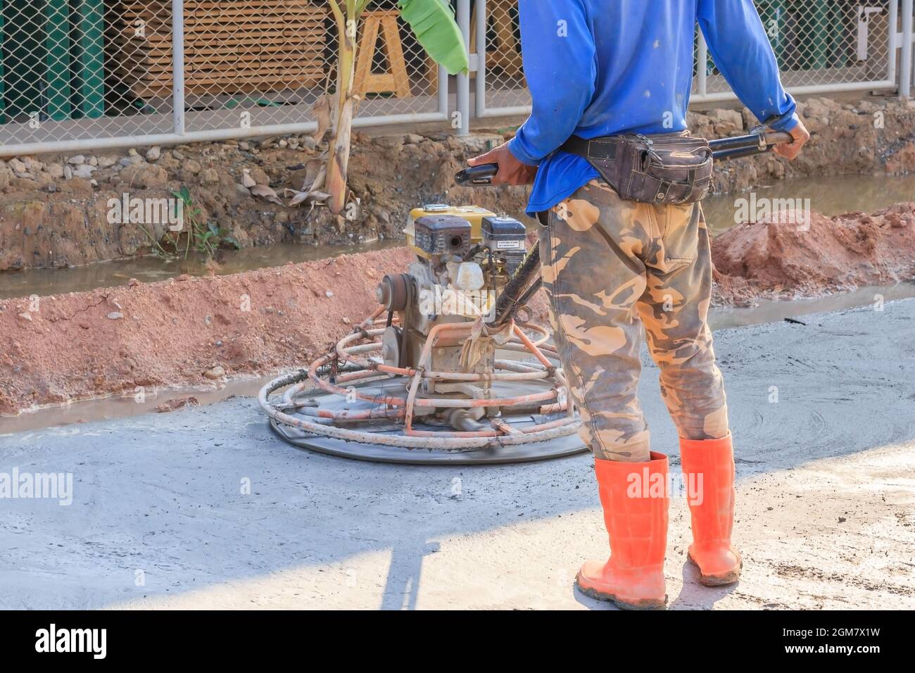 Construction worker produces the grout and finish wet concrete with a