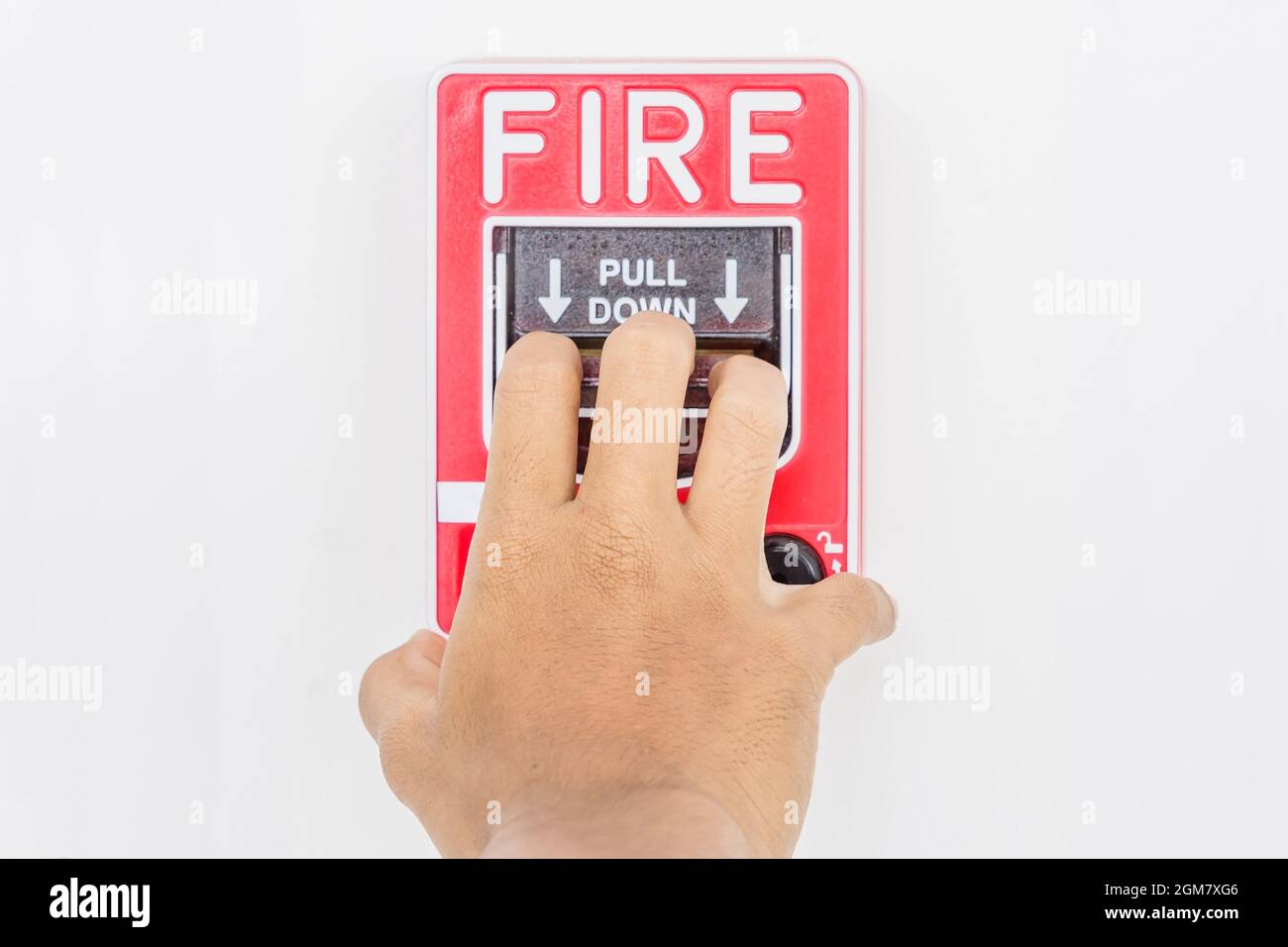 Hand of man pulling fire alarm switch on the white wall as background