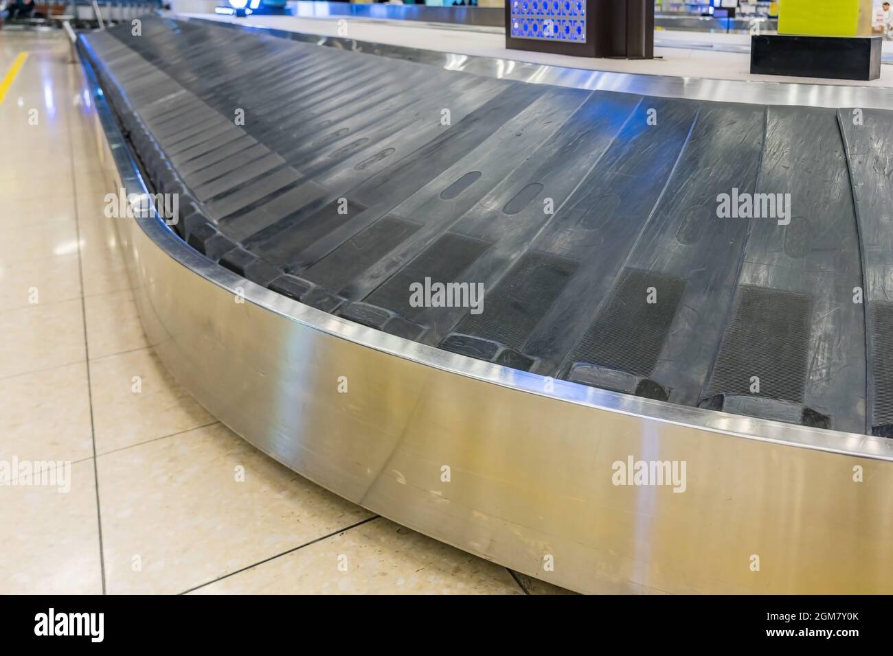 Suitcase on luggage conveyor belt in the baggage claim at airport Stock