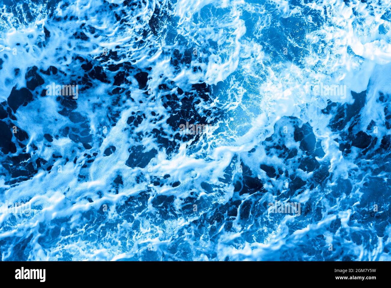 Aerial Ocean water blue surface with foam and waves. Stock Photo