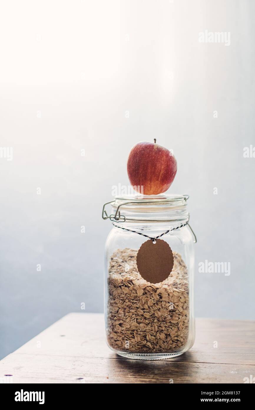 Fruit and fiber - Healthy breakfast with low glycemic index - apple and oatmeal flakes glass jar Stock Photo