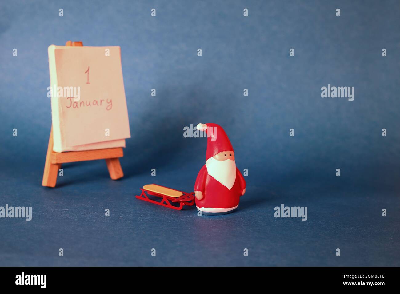 santa claus with empty sleigh walking on the 1-st of January. New year concept on blue background Stock Photo
