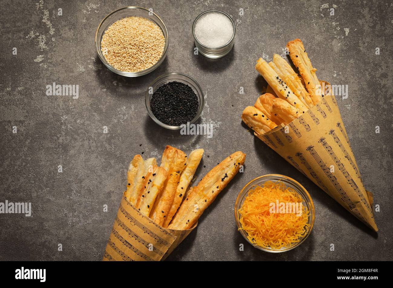 Salted Cheese Straws and Sesame Seeds In A Paper Cone Stock Photo