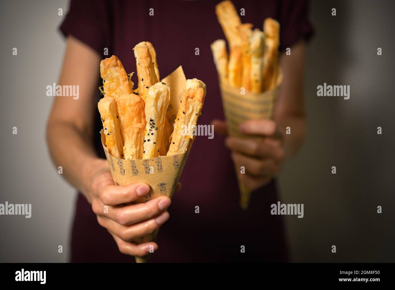 Salted Cheese Straws and Sesame Seeds In A Paper Cone Stock Photo