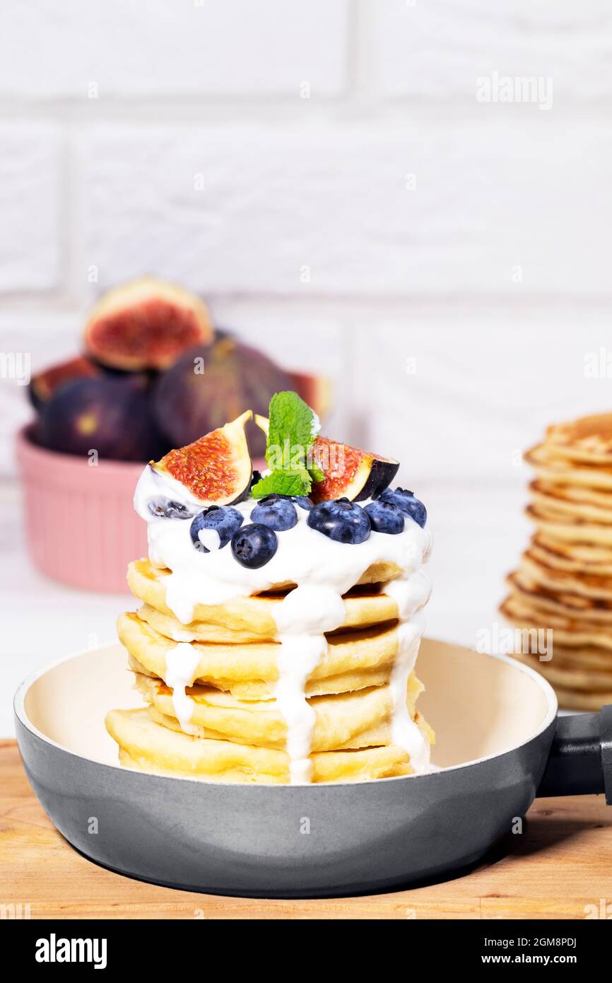 Pancakes with Fig, Blueberry, Youghurt and Mint in pan on white background, Healthy Eating Concept, Traditional American Breakfast Stock Photo