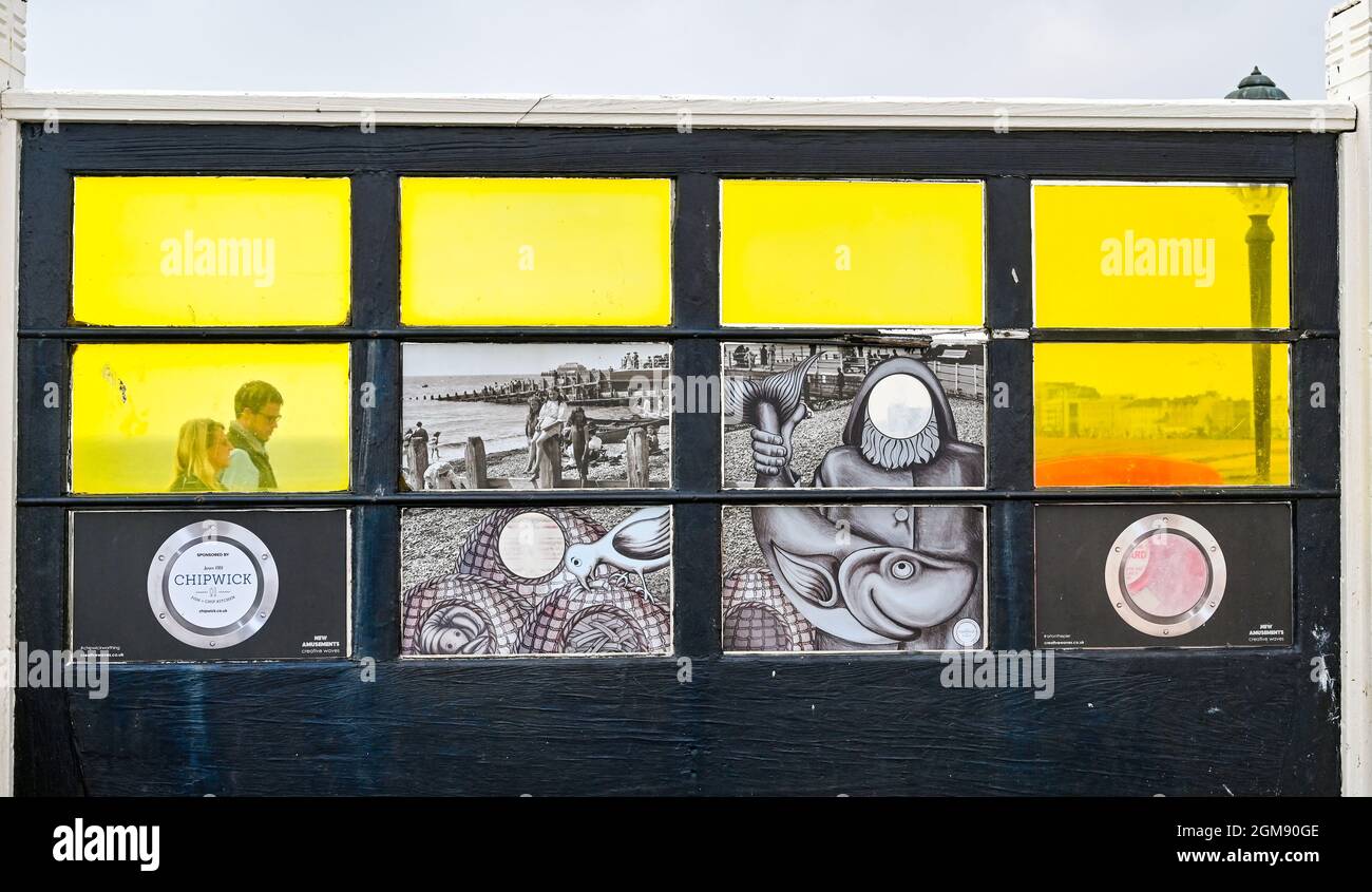 Worthing UK 17th September 2021 -  Visitors walk by the  colourful art windows on Worthing Pier on a hot afternoon along the South  Coast : Credit Simon Dack / Alamy Live News Stock Photo