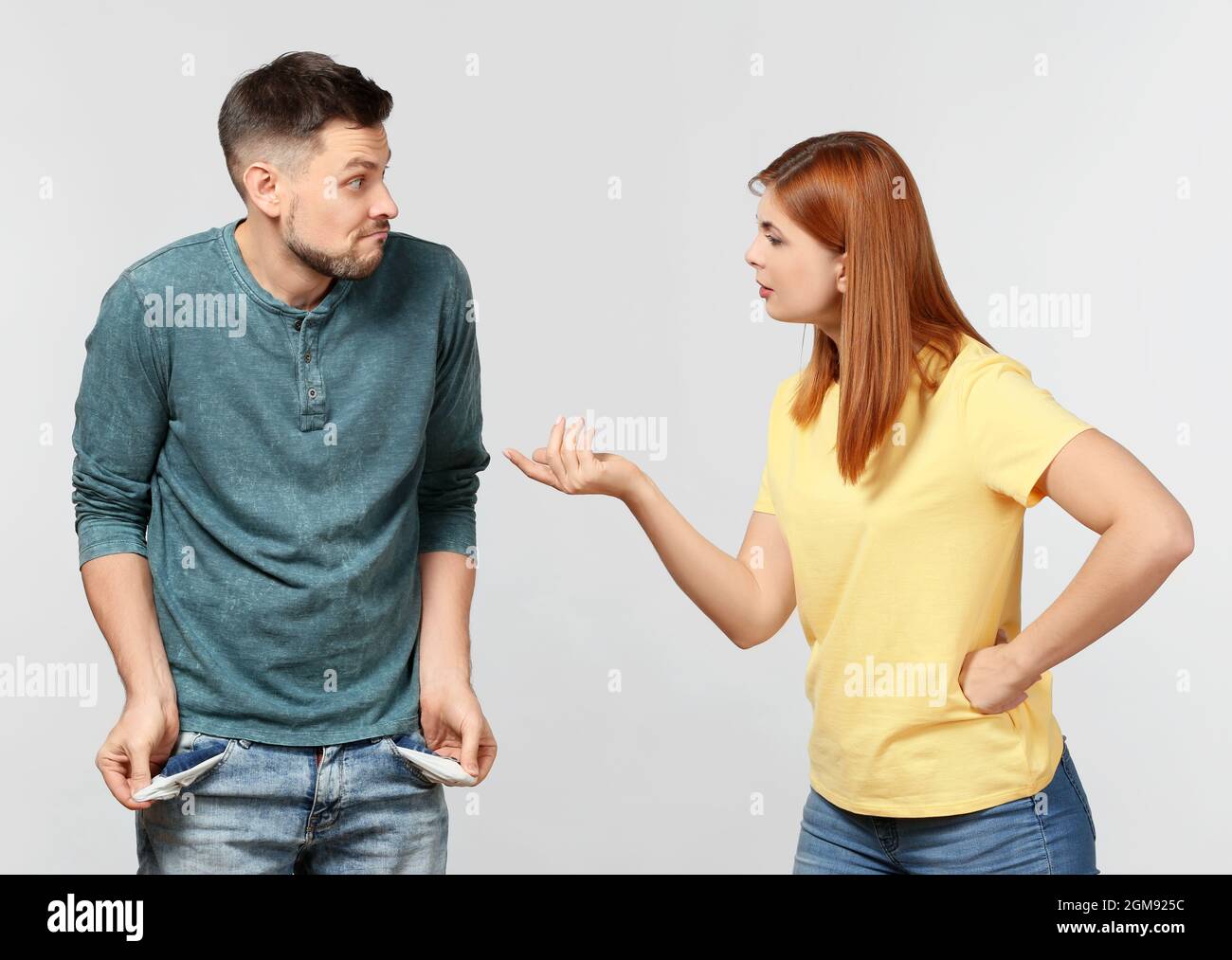 Woman demanding money from her husband who is showing empty pockets on
