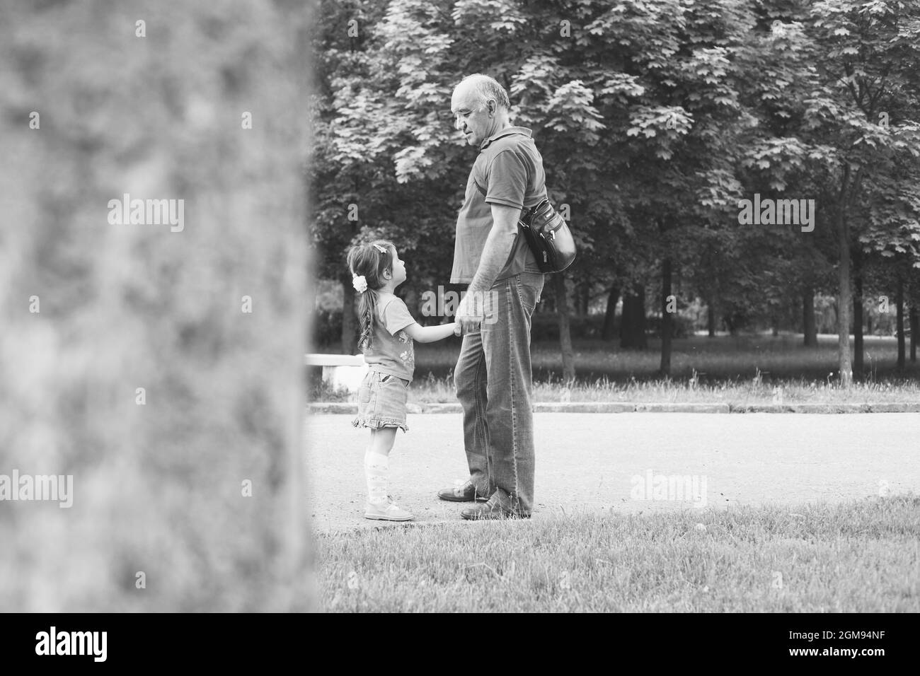 Black and white portrait of Happy grandfather and granddaughter playing outdoors Stock Photo