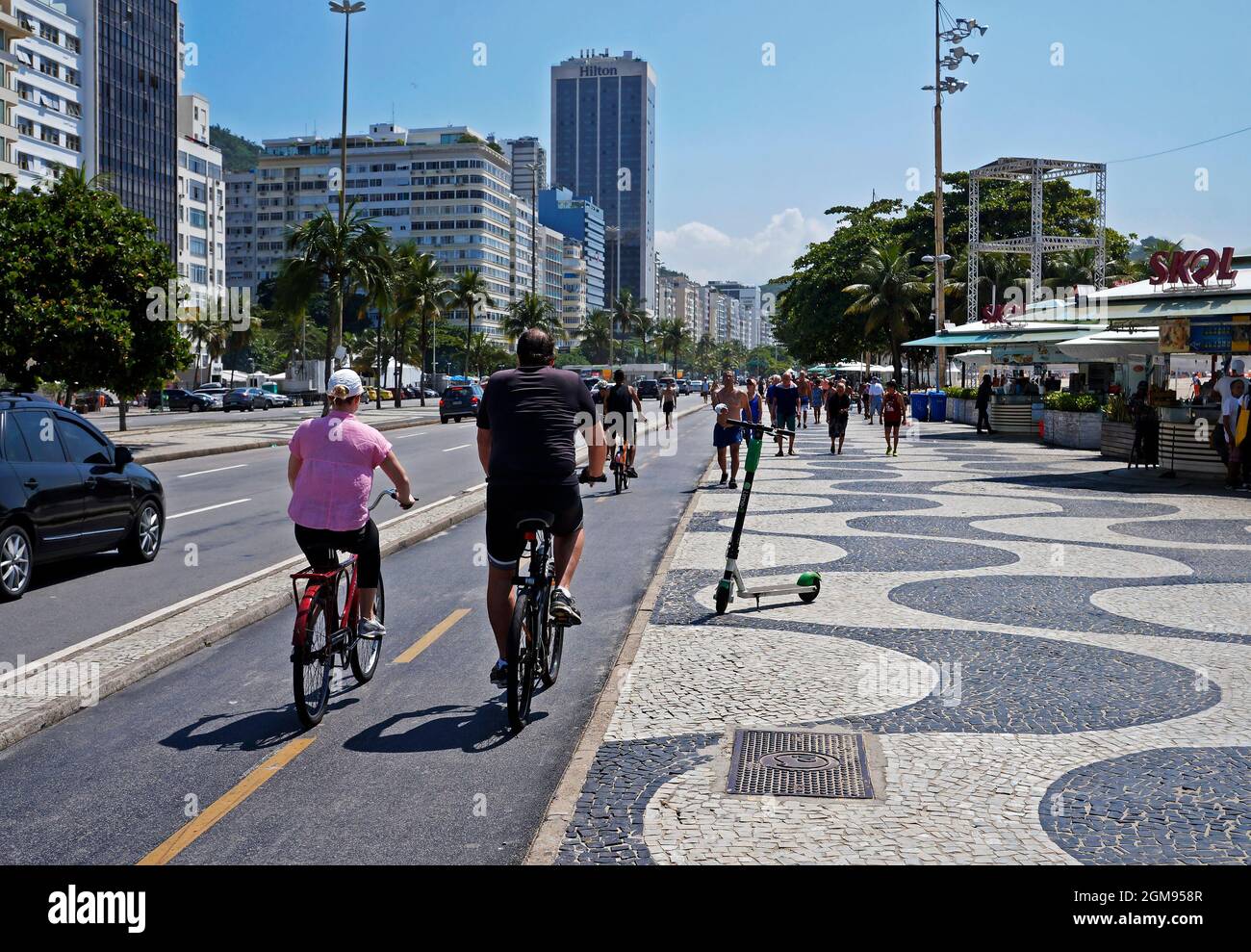 RIO DE JANEIRO, BRAZIL - DECEMBER 27, 2019: People in bike and walking on Copacabana Boardwalk Stock Photo