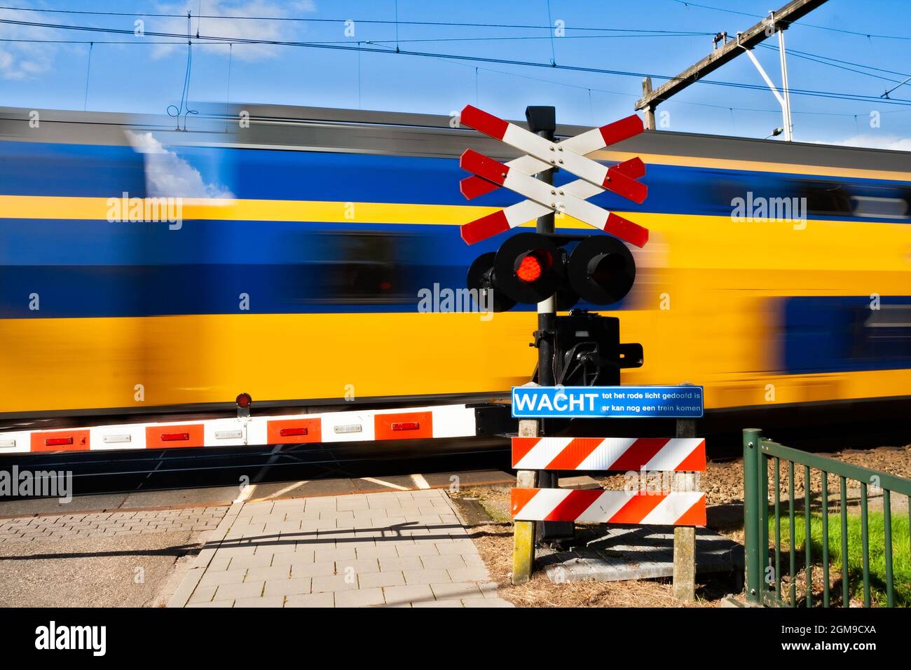 High speed train passing a railway crossing in The Netherlands Stock Photo