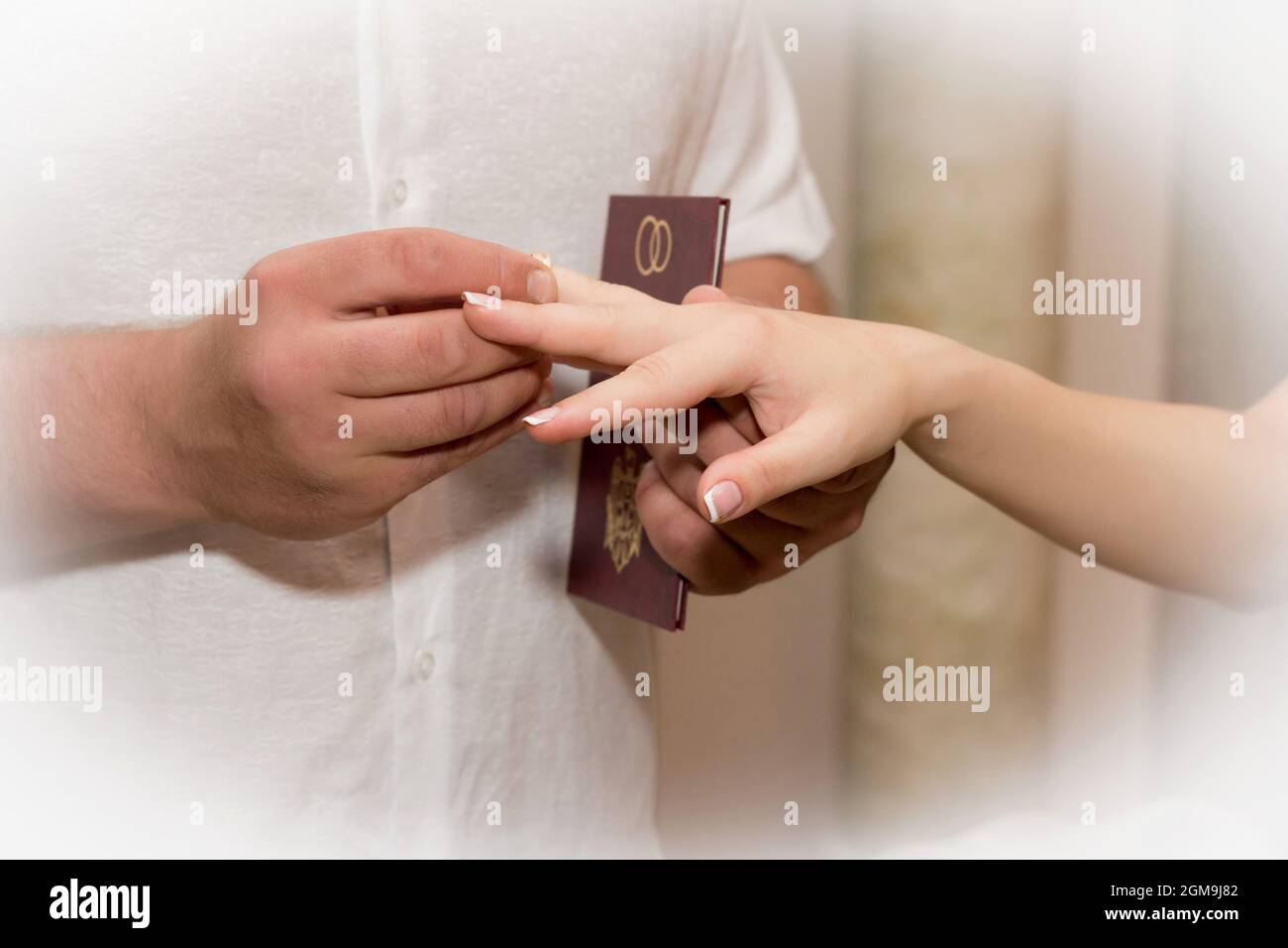 Groom puts wedding ring on bride's finger. Stock Photo