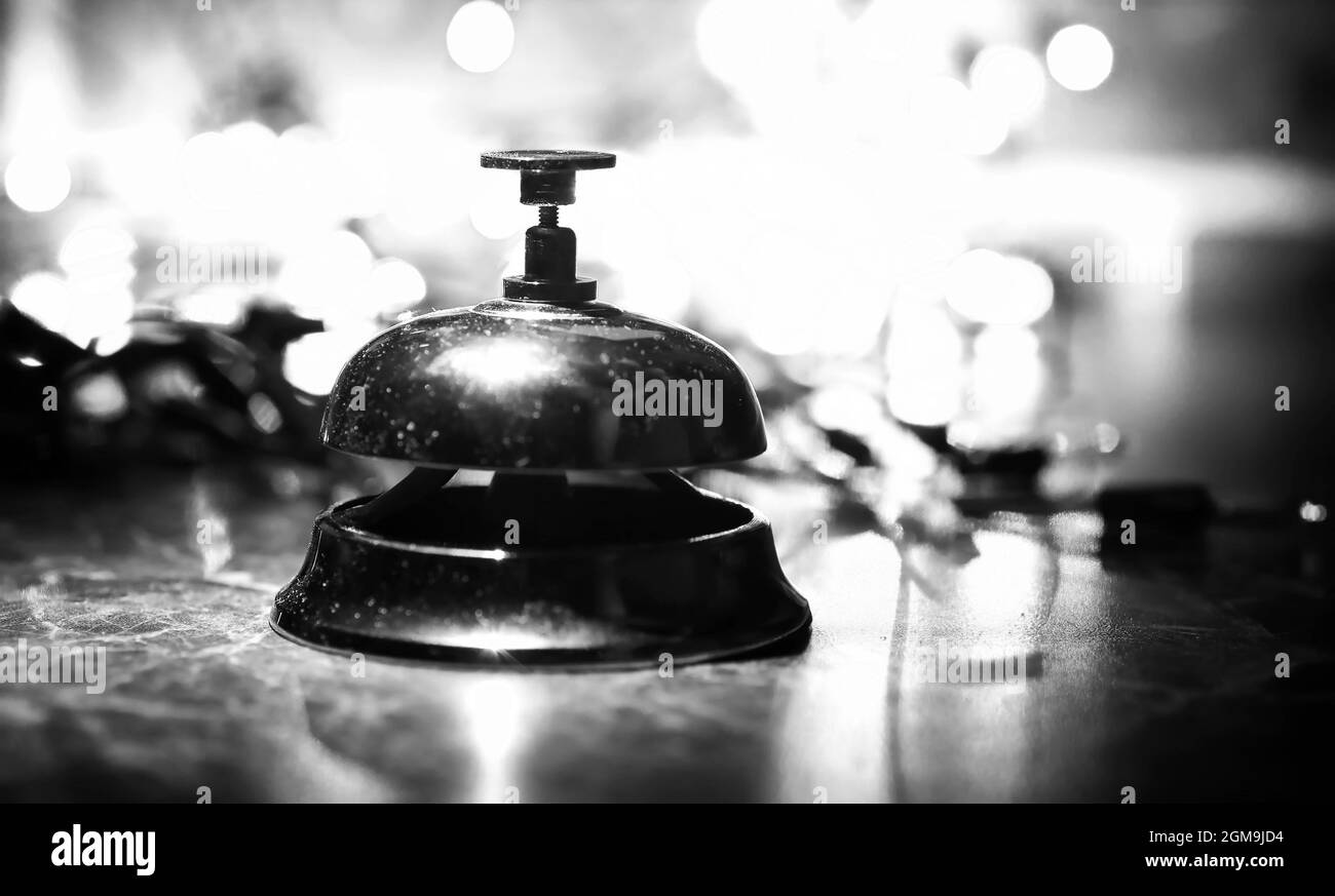reception bell on the table and color shining garland on background ...
