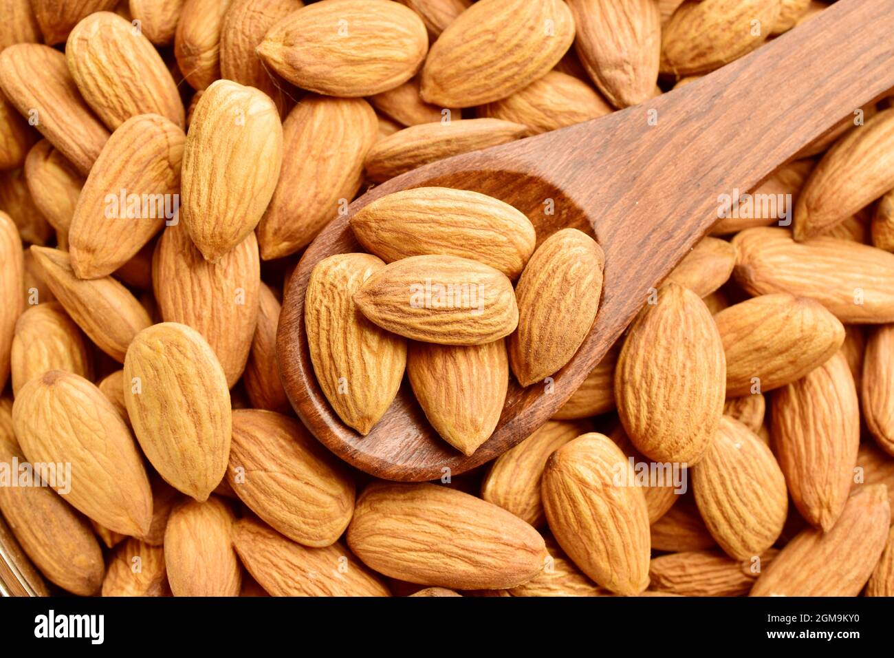 almonds in wooden spoon, top view of badam. Stock Photo