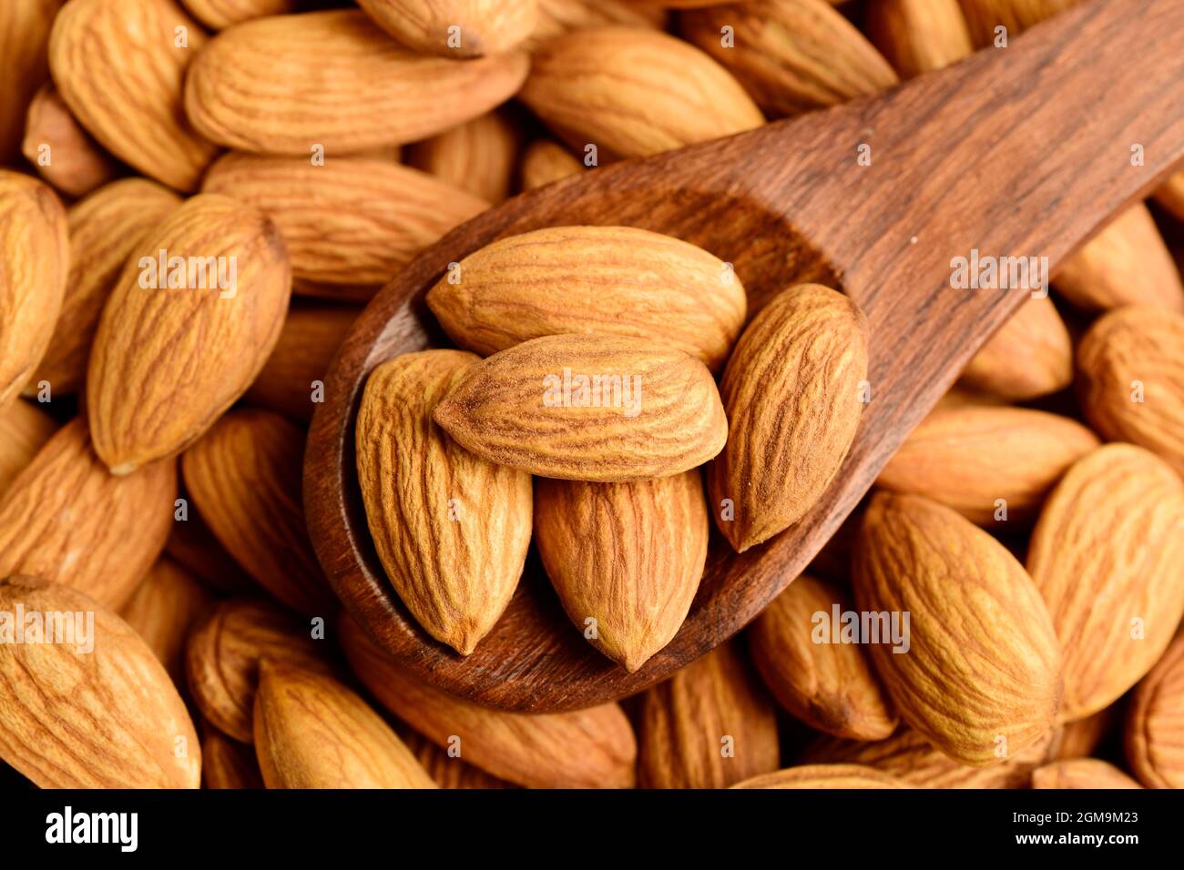 almonds in wooden spoon, top view, badam. Stock Photo