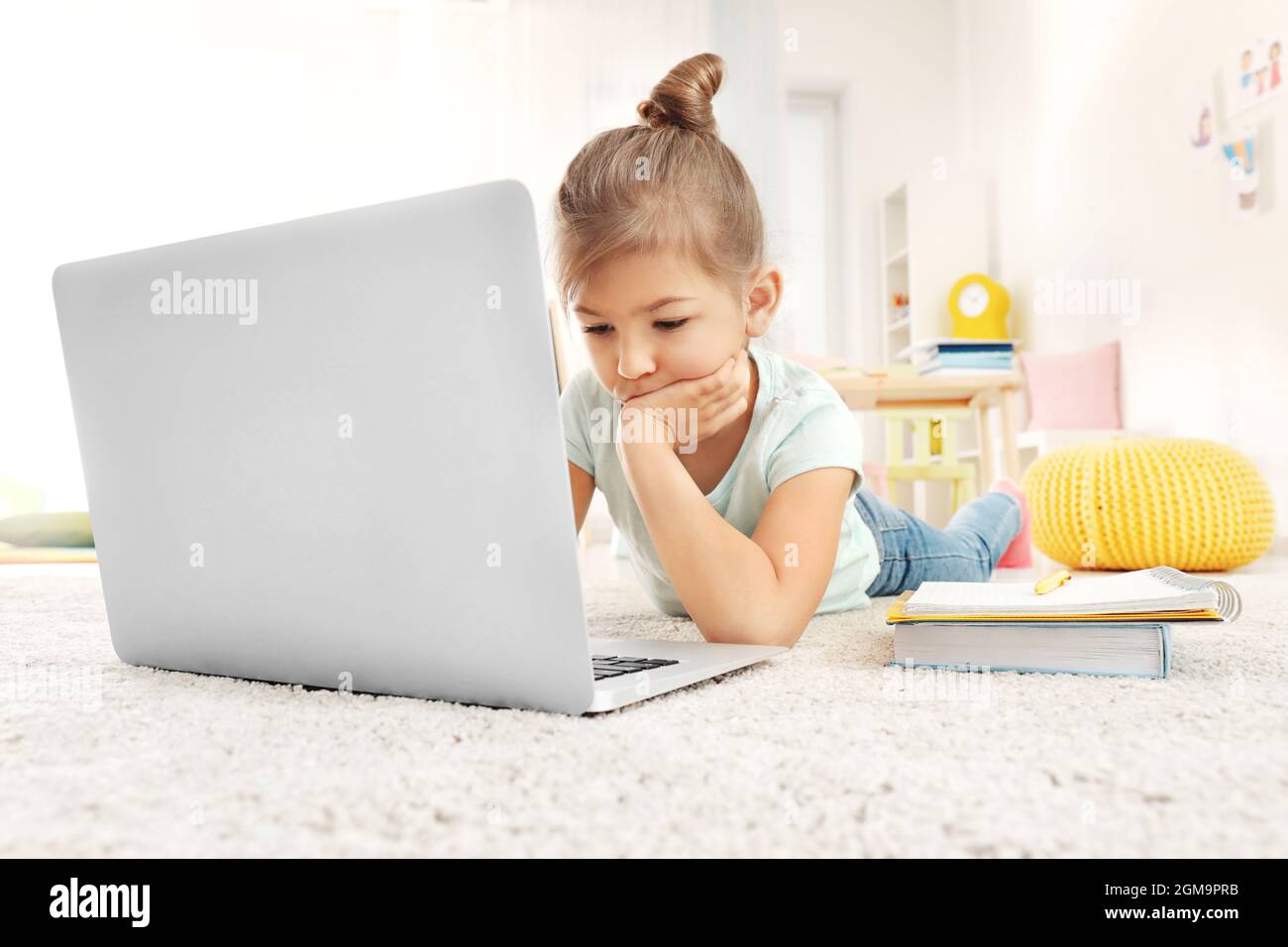 Cute little girl using laptop while doing homework indoors Stock Photo ...