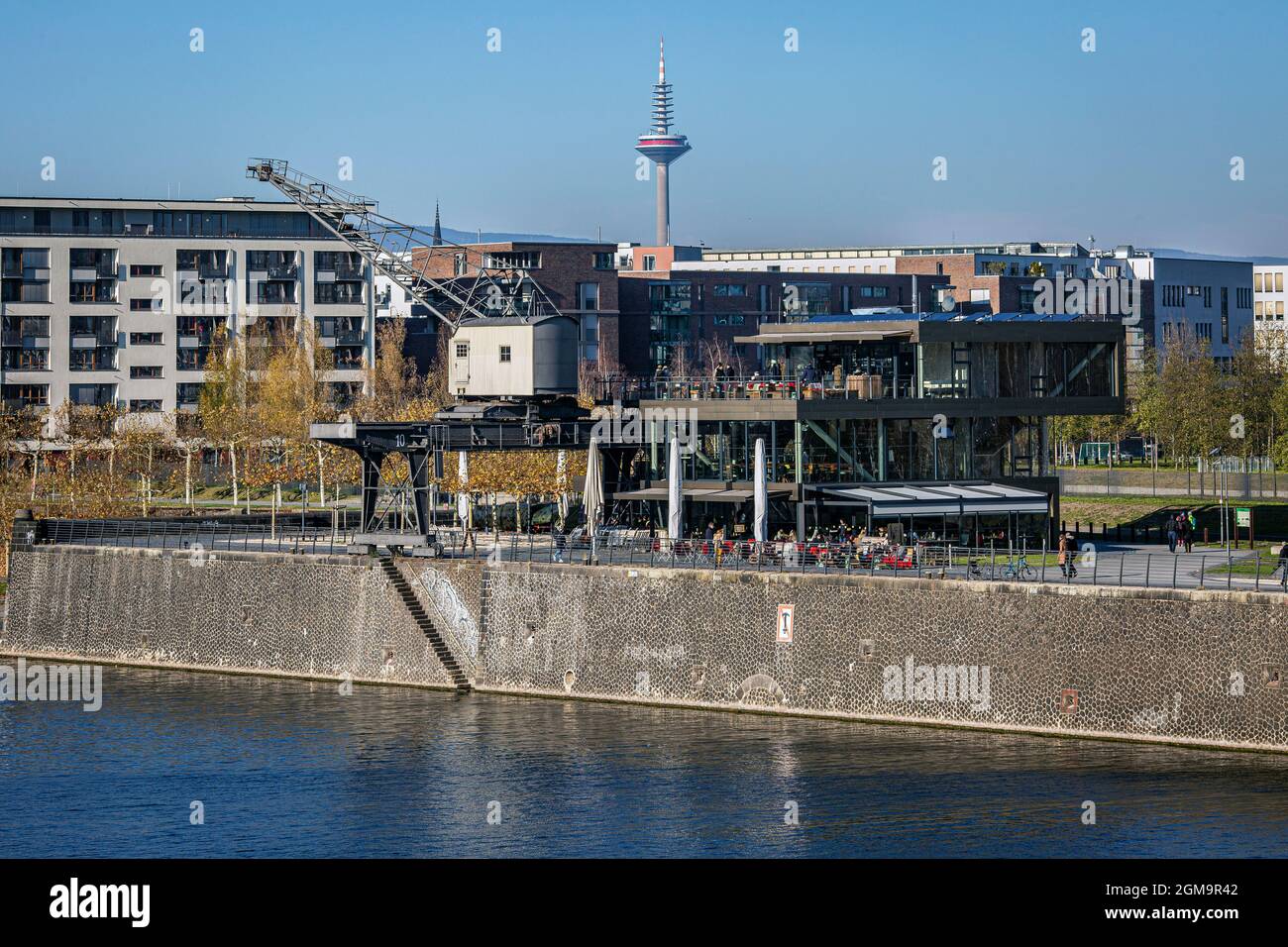 Main river promenade and the restaurant Oosten with the skyline of Frankfurt in the background Stock Photo