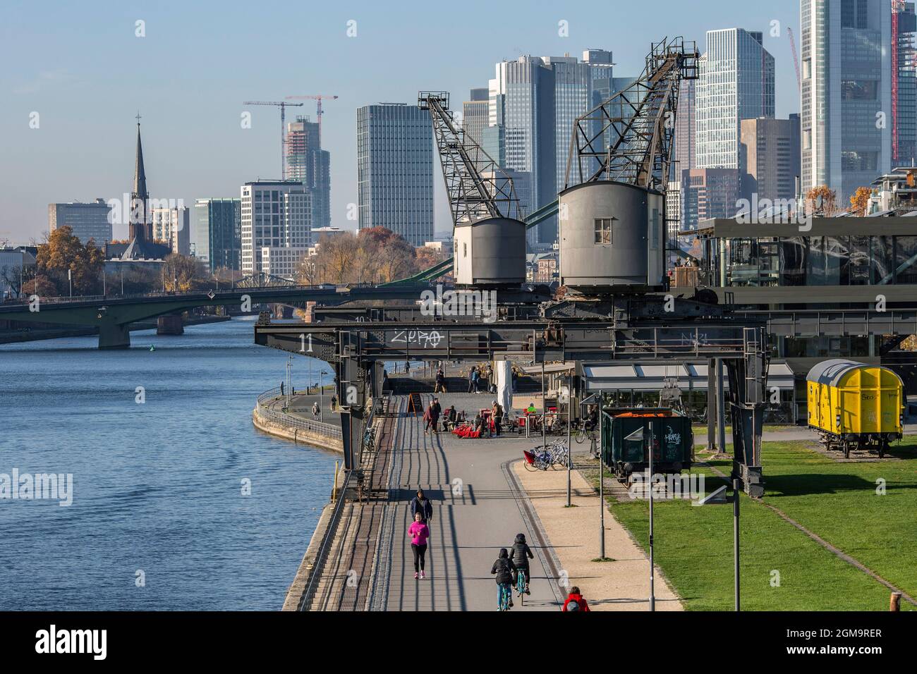 Main river promenade and the restaurant Oosten with the skyline of Frankfurt in the background Stock Photo