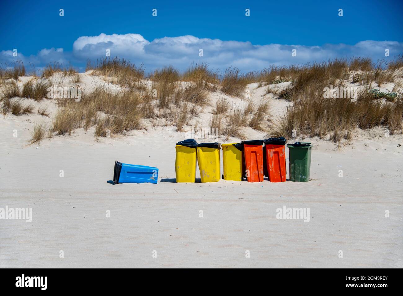 waste-containers in various colors on the beach, to preserve the beach clean from garbage Stock Photo