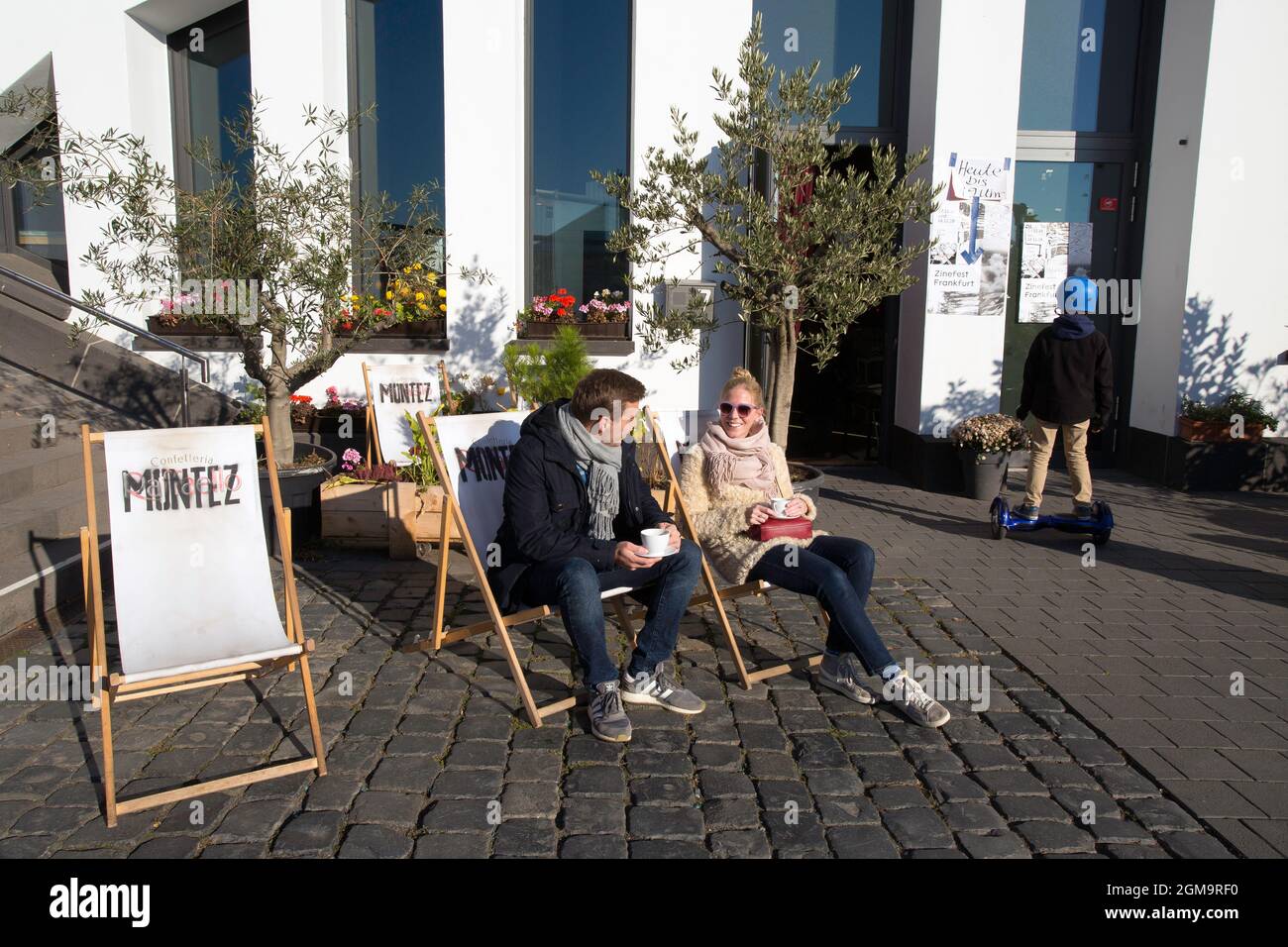 Couple  sitting outside at  Kunstverein Familie Montez in Frankfurt drinking coffee  Germany. Stock Photo