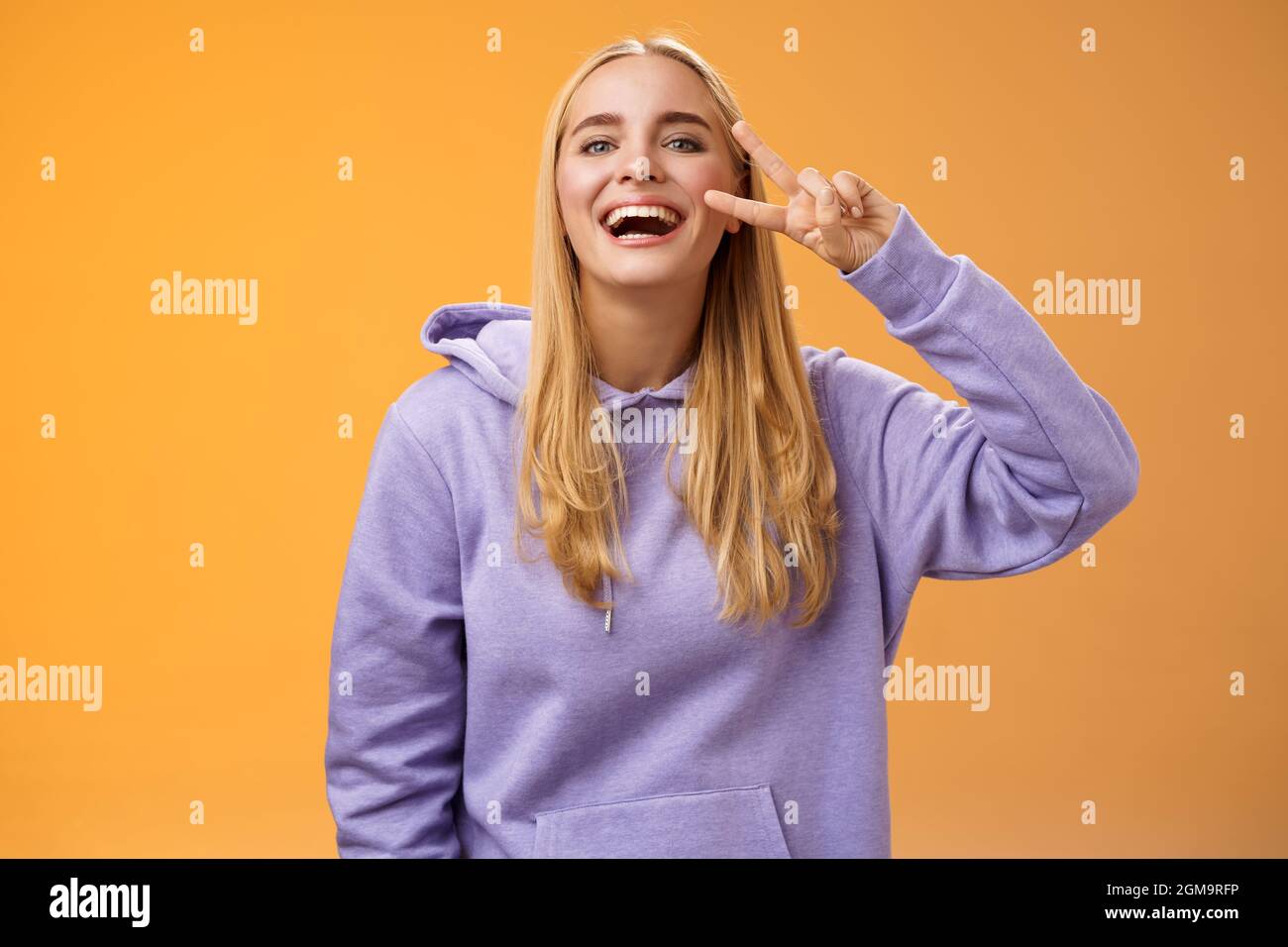 Attractive friendly carefree millennial blond girl in purple hoodie having  fun friends laughing joyfully show peace victory hippie sign adore perfect  Stock Photo - Alamy