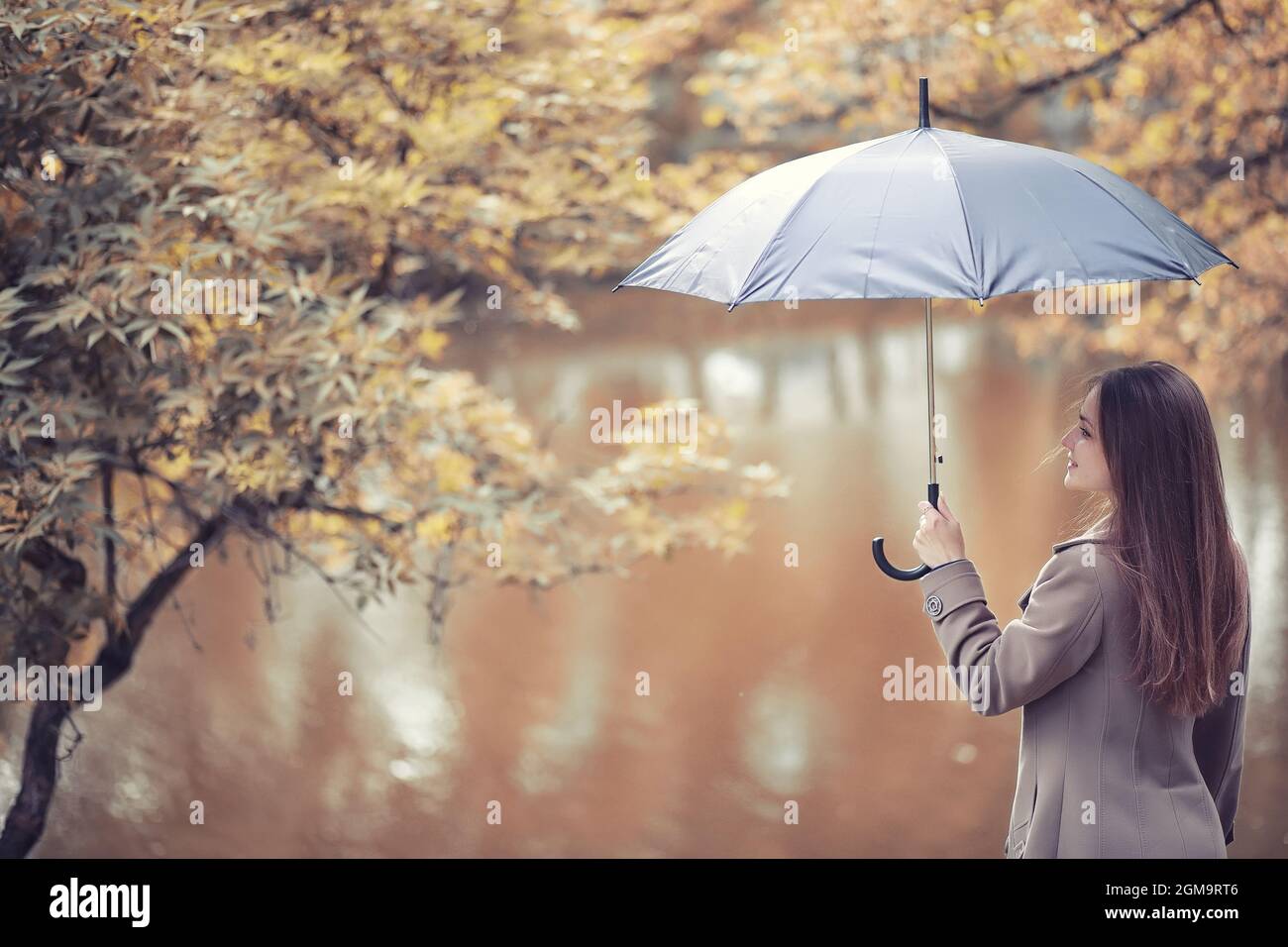 Young girl in a coat in autumn park Stock Photo - Alamy