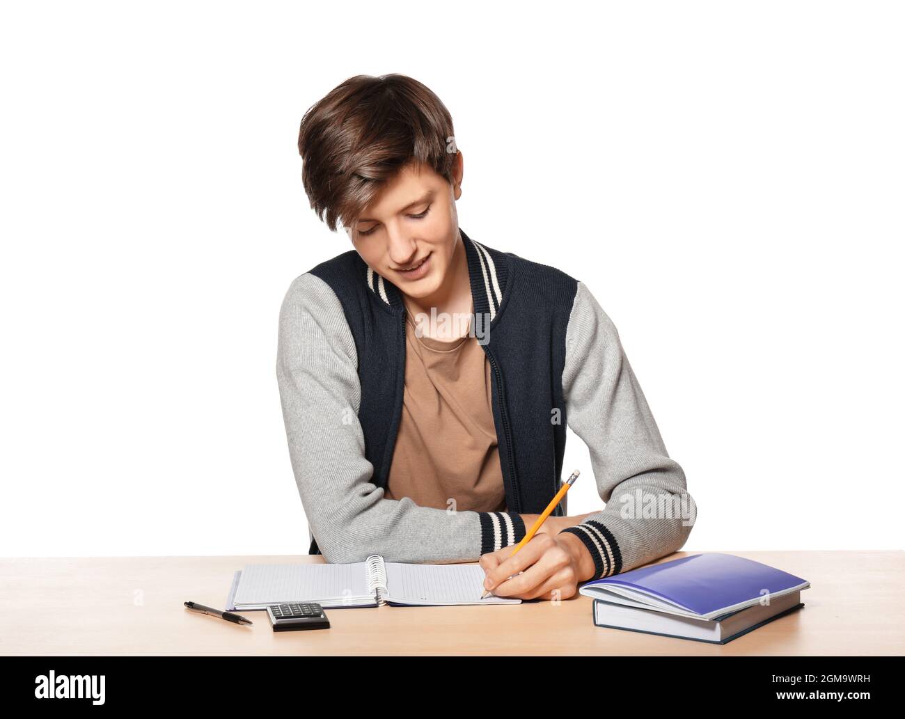 Cute teenager boy doing homework against white background Stock Photo ...