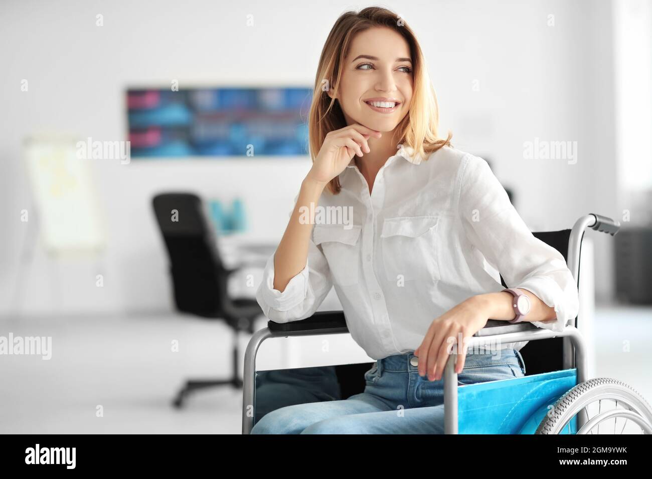 Young woman in wheelchair at workplace Stock Photo - Alamy