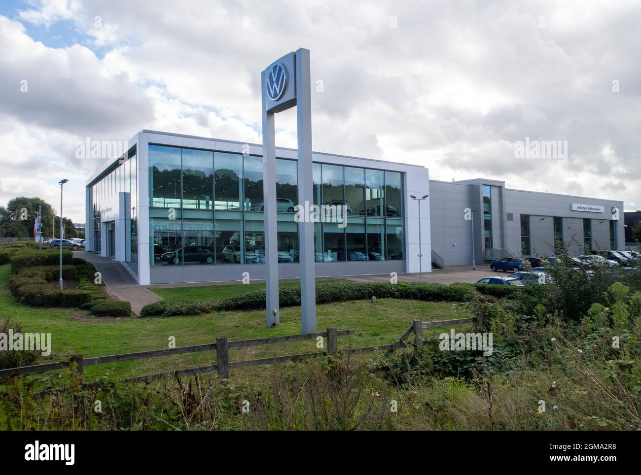 VW Volkswagen car logo and sign outside Inchcape car dealer showroom