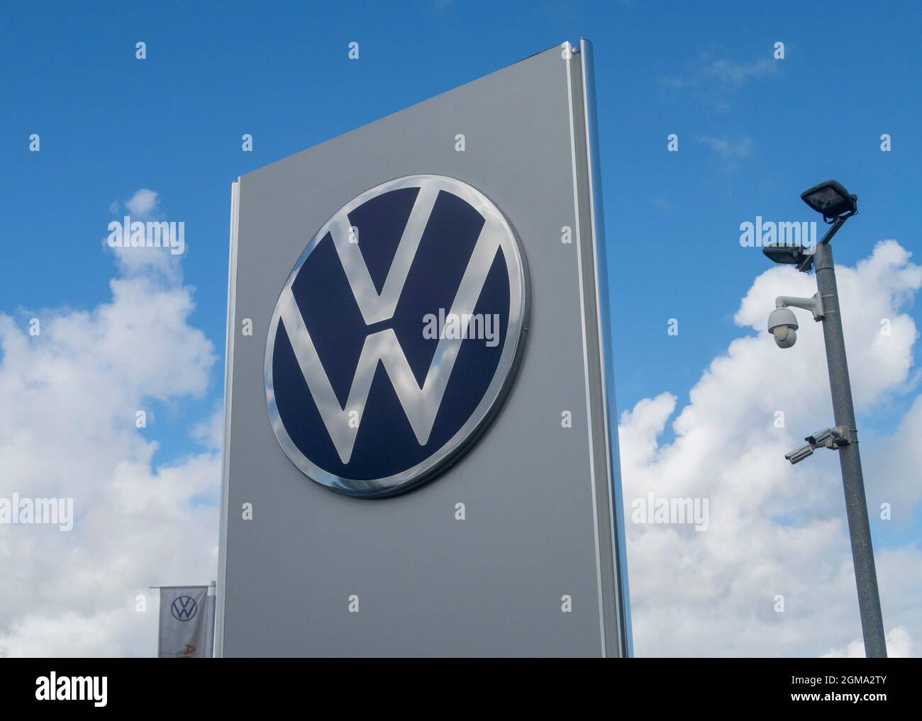 VW Volkswagen car logo and sign outside car dealer showroom, Exeter