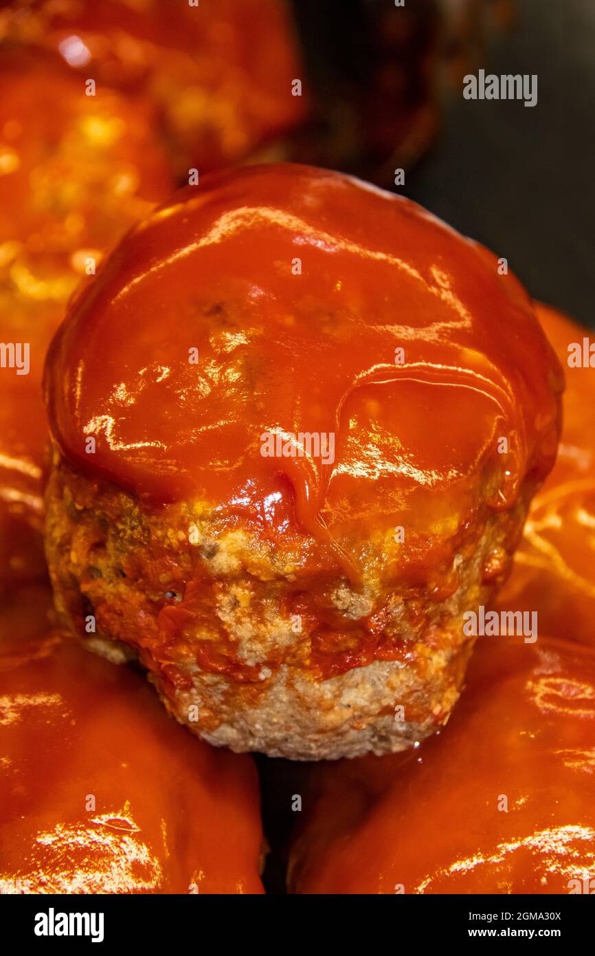 Traditional homemade serving sizes of American meatloaf covered with ketchup stacked in a pan Stock Photo
