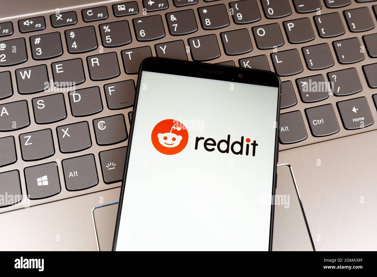 Reddit logo on smartphone screen on keyboard. Reddit is a social news aggregation, web content rating, and discuss Stock Photo
