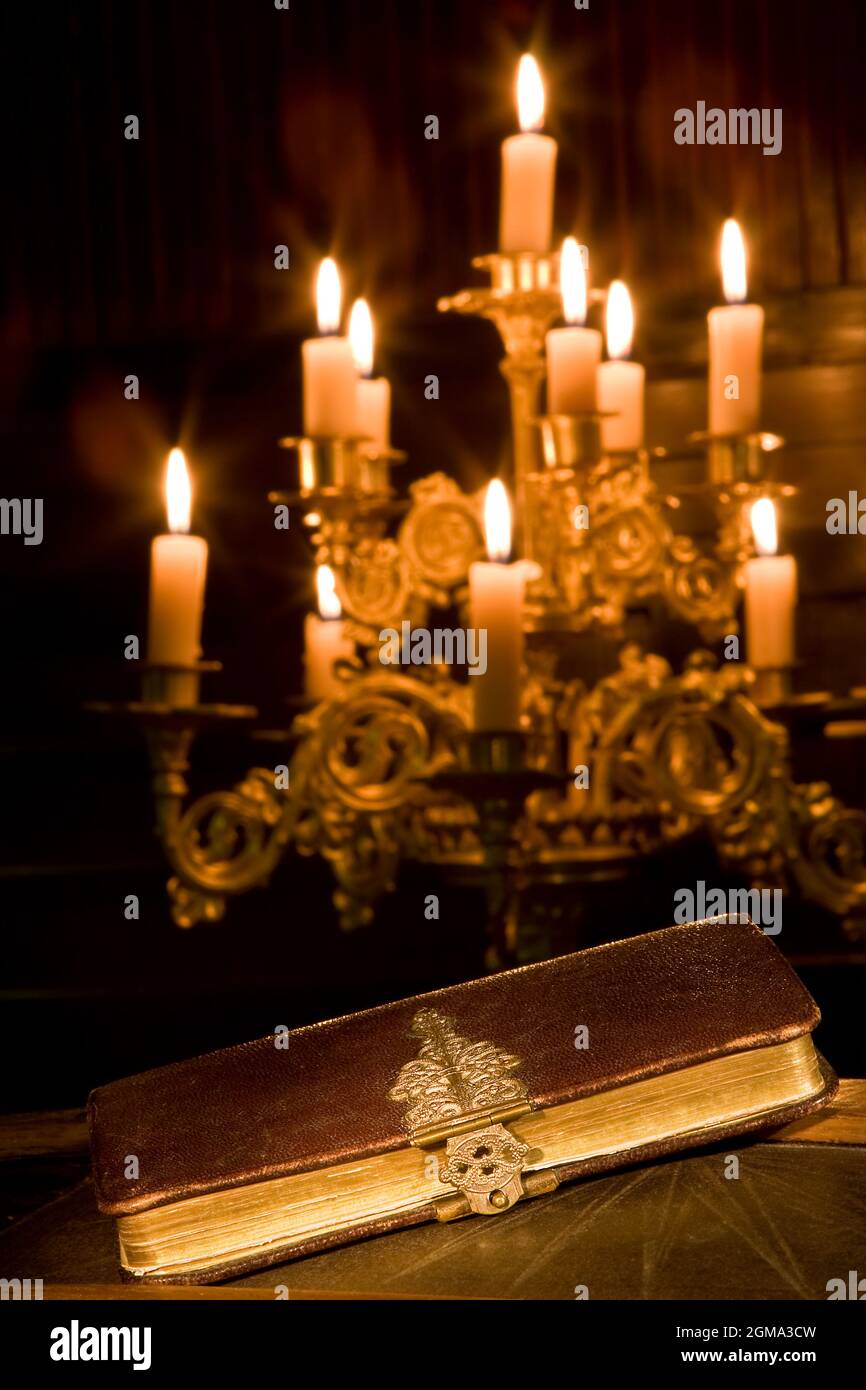Antique bible in a chapel with candles Stock Photo