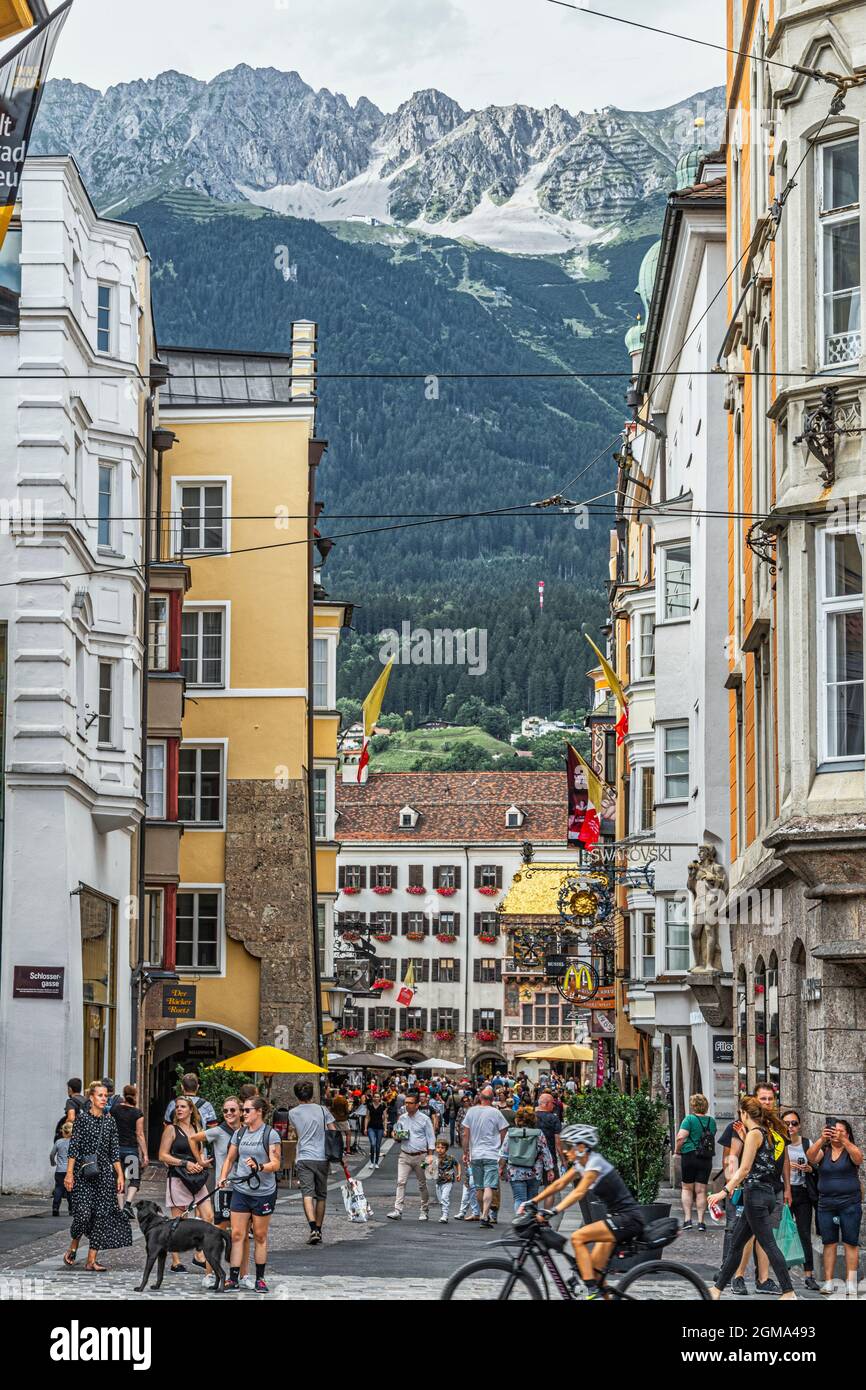 Strolling tourists visit the Golden Roof, Goldenes Dachl, and the picturesque decorated houses on Herzog-Friedrich-Strasse. Innsbruck, Tyrol, Austria Stock Photo