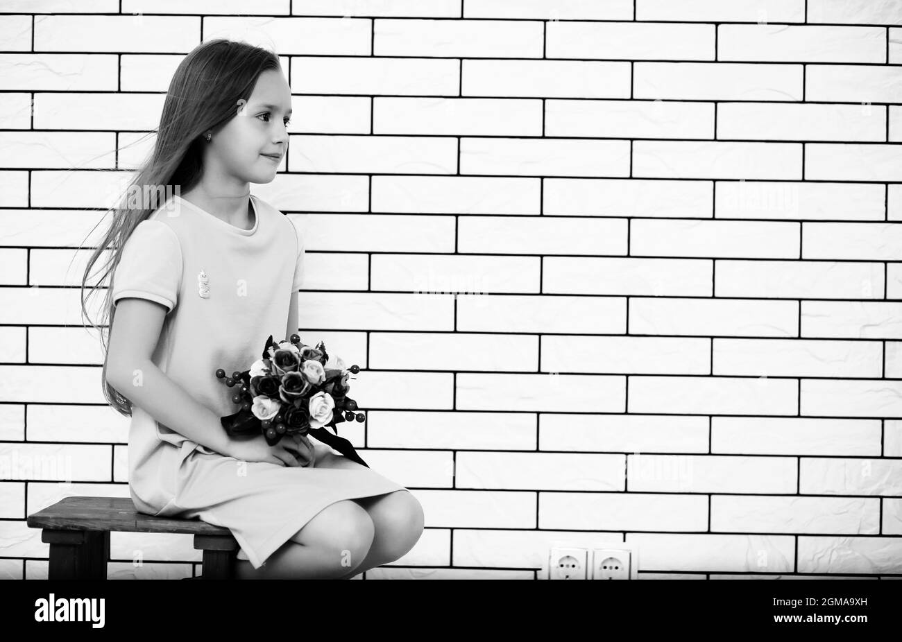 little girl is sitting on a chair and posing on the camera Stock Photo ...