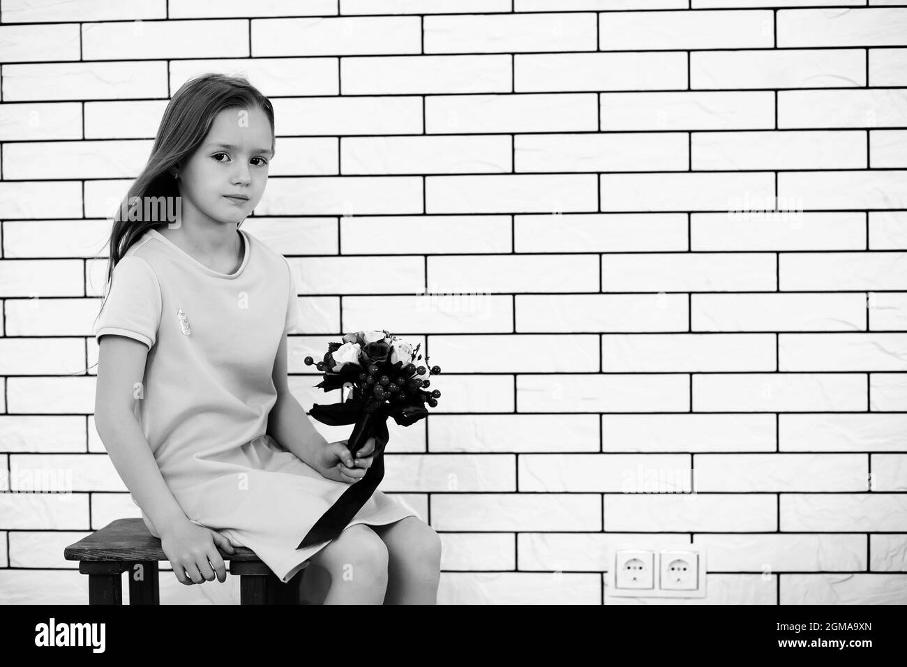 little girl is sitting on a chair and posing on the camera Stock Photo ...