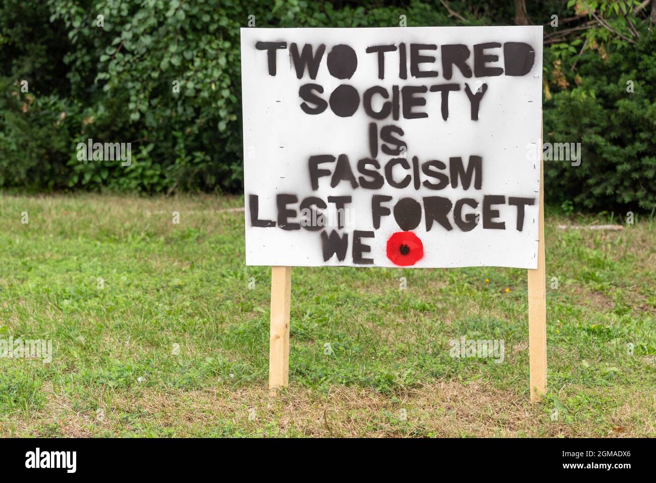 A protest sign in Bayview Avenue in Toronto, Canada. The sign reads 'Two Tiered Society is Facism. Lest We Forget'. The Bayview area is perceived to b Stock Photo