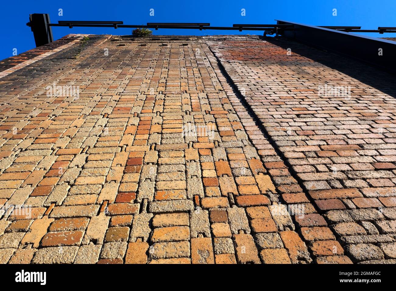 Bottom view orange colored grungy brick wall as background Stock Photo